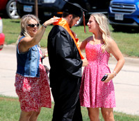 Heather Reimers & Candace Heggemeyer help out Dylan Reimers adjust his stole in preparation of graduation ceremonies at LCC.